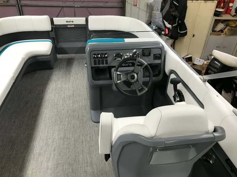 Slide: The Image of 2025 Avalon AURA boat interior with white and teal seating, modern helm, and spacious layout. - 12
