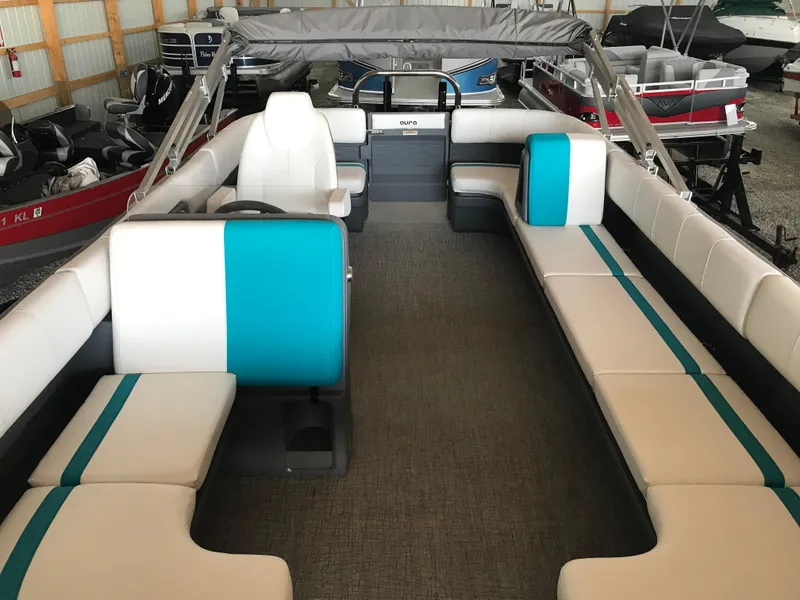 Slide: The Image of 2025 Avalon AURA boat interior with white and teal seating, gray flooring. - 25