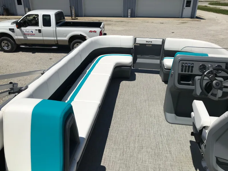 Slide: The Image of 2025 Avalon AURA boat interior with white and teal seating on a sunny day. - 36