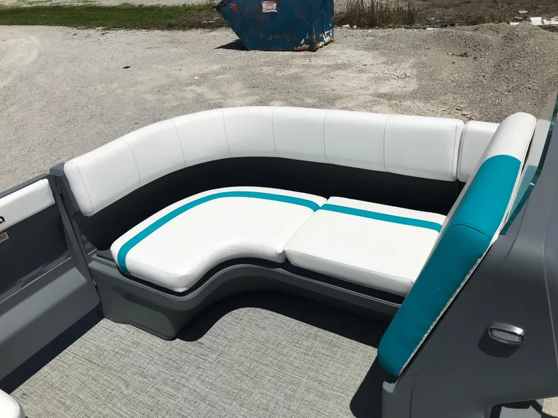 Slide: The Image of 2025 Avalon AURA boat interior with white and teal seating, parked near a white pickup truck. - 39