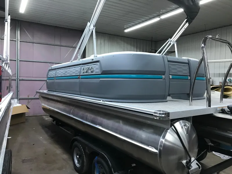 Slide: The Image of 2025 Avalon AURA boat on trailer outside large storage building. - 4