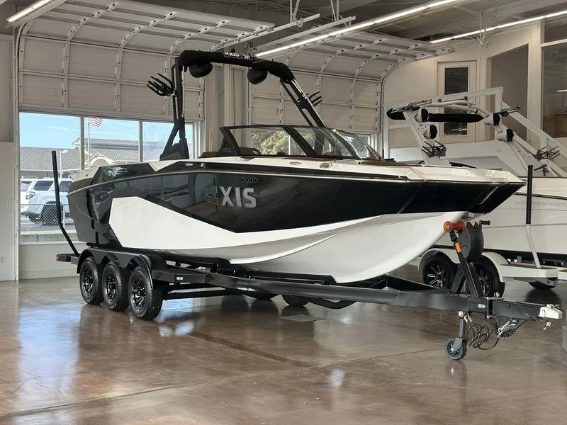 The Image of 2025 Axis A245 boat on trailer in showroom, featuring sleek black and white design. - 0