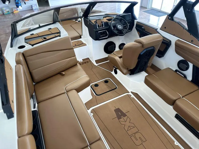 Slide: The Image of 2025 Axis A245 boat interior with tan seating and modern dashboard design. - 13