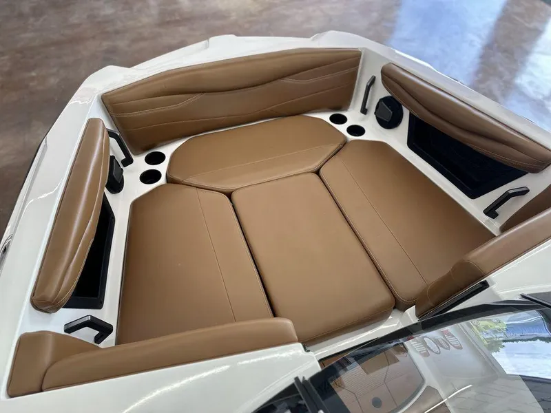 Slide: The Image of 2025 Axis A245 boat interior with tan leather seating and cup holders. - 19