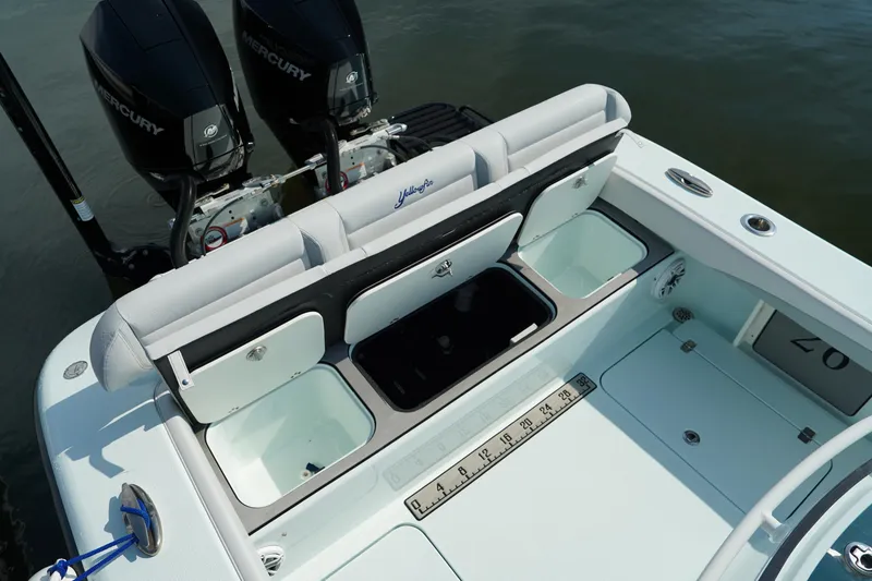 Slide: The Image of 2020 Yellowfin 26 Hybrid boat with open storage compartments and dual Mercury engines. - 11