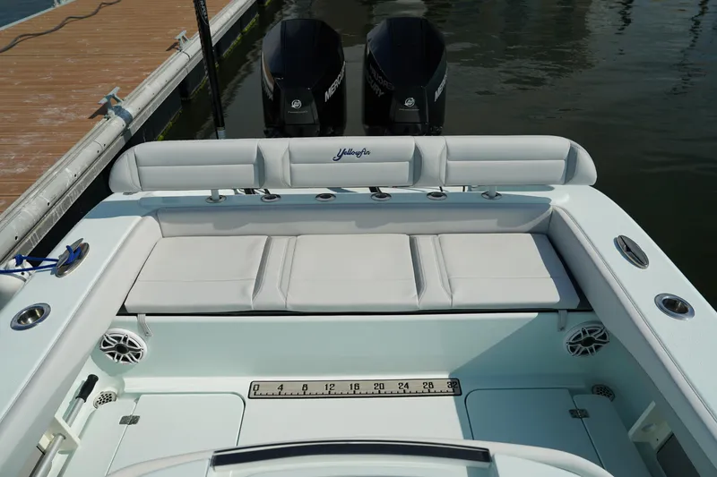 Slide: The Image of 2020 Yellowfin 26 Hybrid boat with cushioned seating and dual outboard motors at a dock. - 14