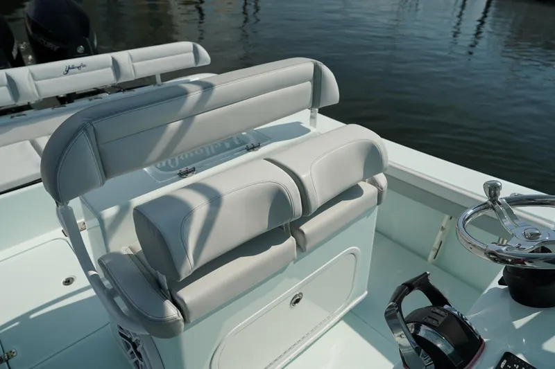 Slide: The Image of 2020 Yellowfin 26 Hybrid boat interior with cushioned seating and steering wheel. - 16