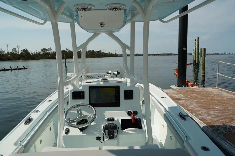 Slide: The Image of 2020 Yellowfin 26 Hybrid boat at dock, featuring modern navigation controls and steering wheel. - 21