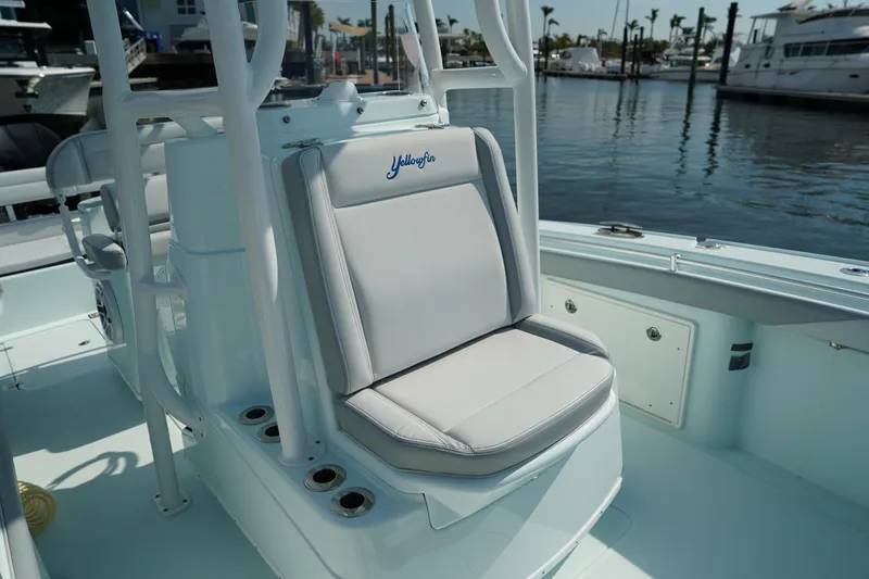 Slide: The Image of 2020 Yellowfin 26 Hybrid boat interior with cushioned seating and rod holders. - 30
