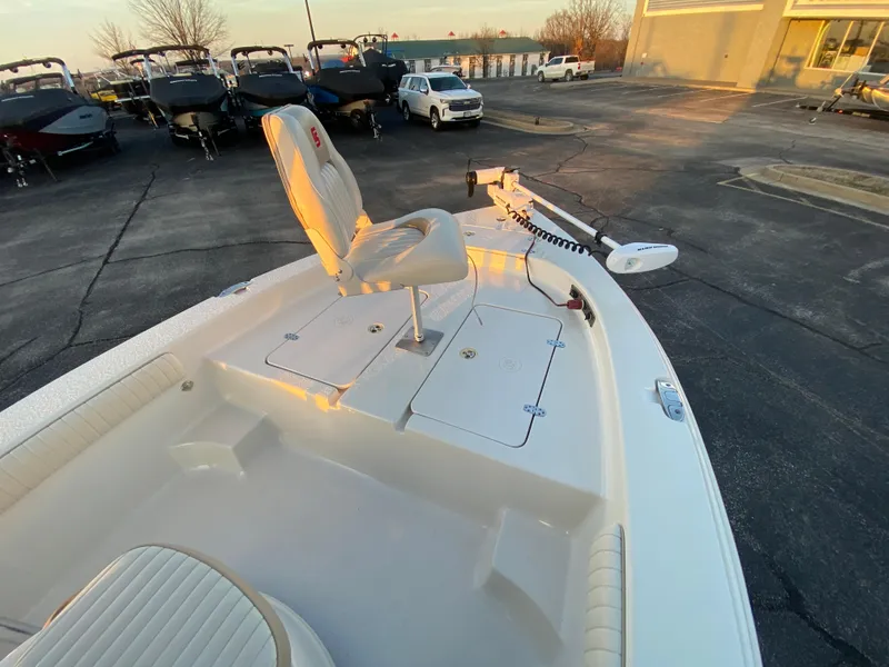 Slide: The Image of 2017 Carolina Skiff Sea Skiff 21CC boat with seating, parked in a lot at sunset. - 23