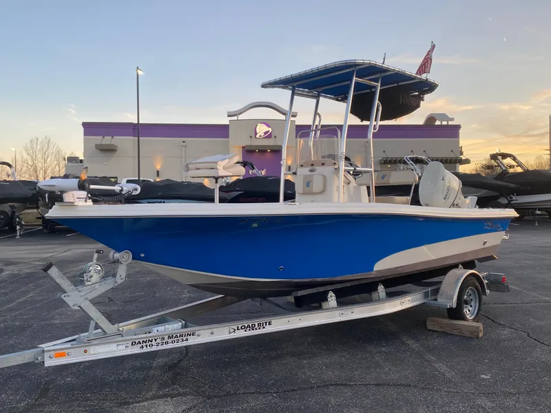 Slide: The Image of 2017 Carolina Skiff Sea Skiff 21CC boat on trailer, blue hull, parked outdoors. - 29