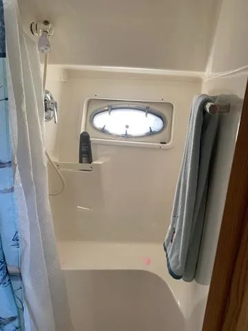 Slide: The Image of 1999 Tiara Yachts 3500 Express bathroom with shower and porthole window. - 11