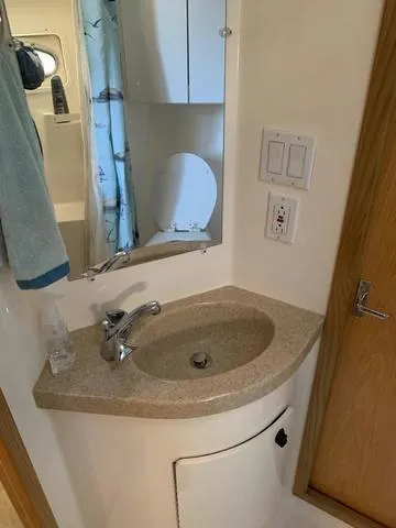 Slide: The Image of 1999 Tiara Yachts 3500 Express bathroom with sink, mirror, and wooden door. - 12