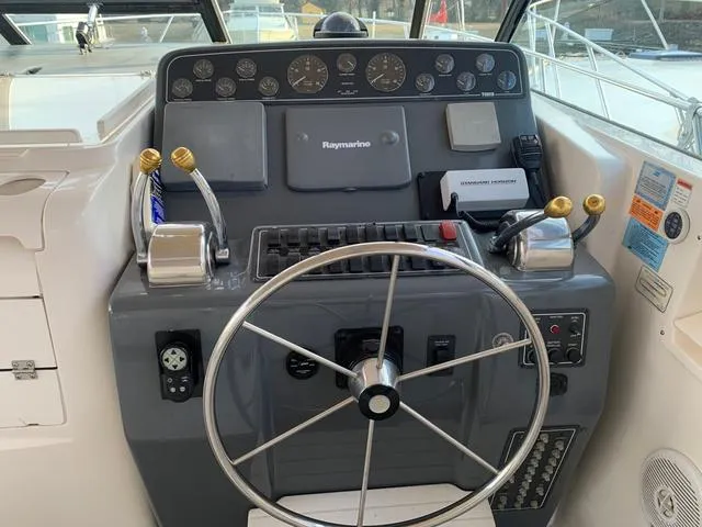 Slide: The Image of 1999 Tiara Yachts 3500 Express helm with steering wheel and control panel. - 16