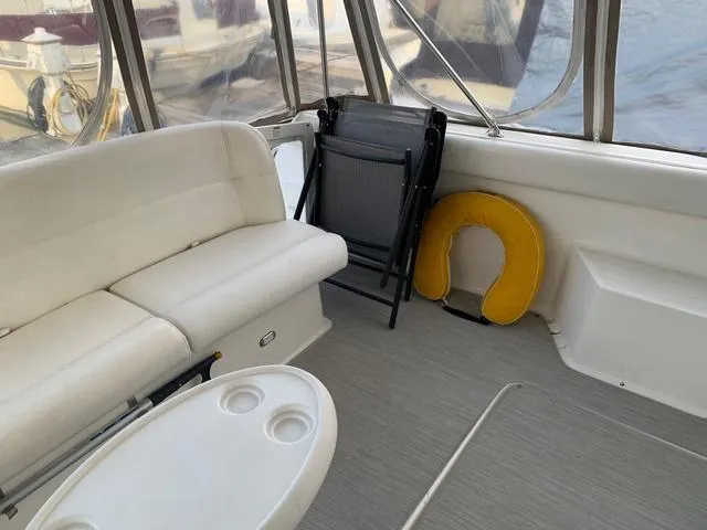 Slide: The Image of 1999 Tiara Yachts 3500 Express interior with seating, table, and life preserver. - 18