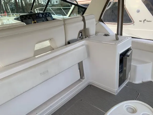 Slide: The Image of 1999 Tiara Yachts 3500 Express interior with white seating and compact kitchenette. - 20