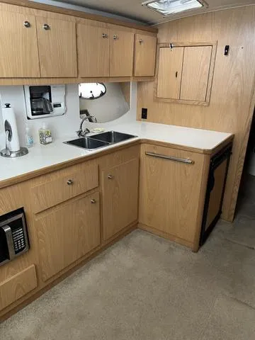 Slide: The Image of 1999 Tiara Yachts 3500 Express kitchen with wood cabinets and modern appliances. - 24