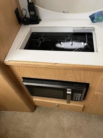 Slide: The Image of 1999 Tiara Yachts 3500 Express kitchen with stove and microwave. - 26