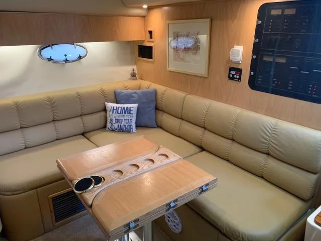 Slide: The Image of Interior of 1999 Tiara Yachts 3500 Express with beige seating and wooden table. - 6
