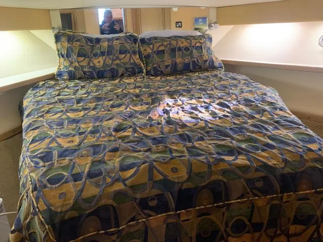 Slide: The Image of 1999 Tiara Yachts 3500 Express cabin with patterned bedding and ambient lighting. - 7