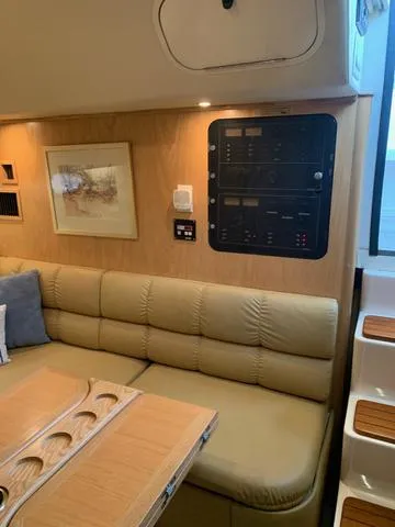 Slide: The Image of Interior of 1999 Tiara Yachts 3500 Express, featuring a beige leather sofa and control panel. - 9