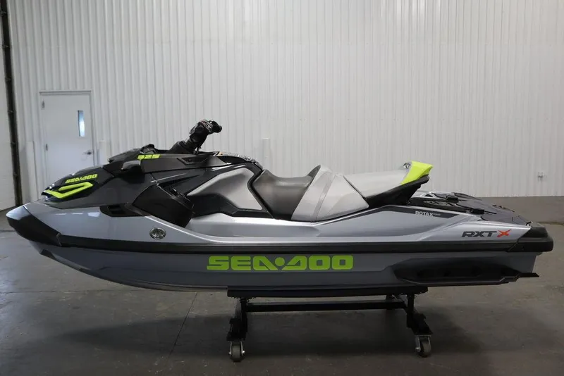 Slide: The Image of 2025 Sea-Doo RXT-X™ 325 in Ice Metal and Manta Green, displayed indoors. - 16