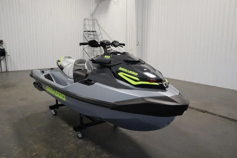 Slide: The Image of 2025 Sea-Doo RXT-X™ 325 in Ice Metal and Manta Green, displayed indoors. - 21