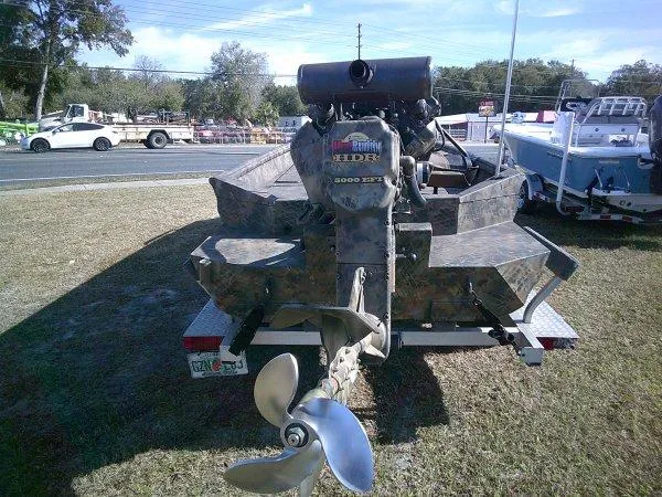 Slide: The Image of Excel 1854 SWV4T boat on trailer, camo design, parked outdoors, 2026 model. - 3