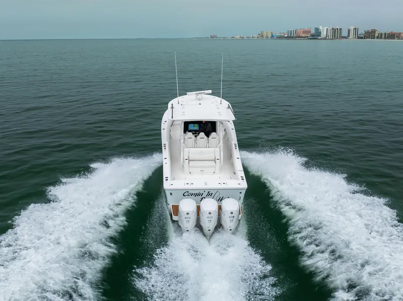 Slide: The Image of 2023 Regulator 37 boat cruising on open water, city skyline in background. - 10