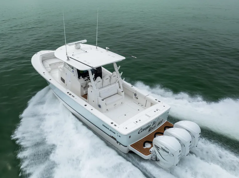 Slide: The Image of 2023 Regulator 37 boat cruising on open water, featuring triple outboard engines. - 13