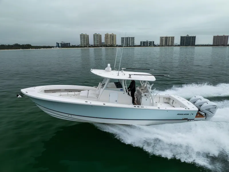 Slide: The Image of 2023 Regulator 37 boat cruising on water with city skyline in background. - 16