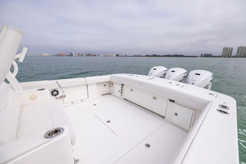Slide: The Image of 2023 Regulator 37 boat deck with triple outboard motors on calm water. - 22