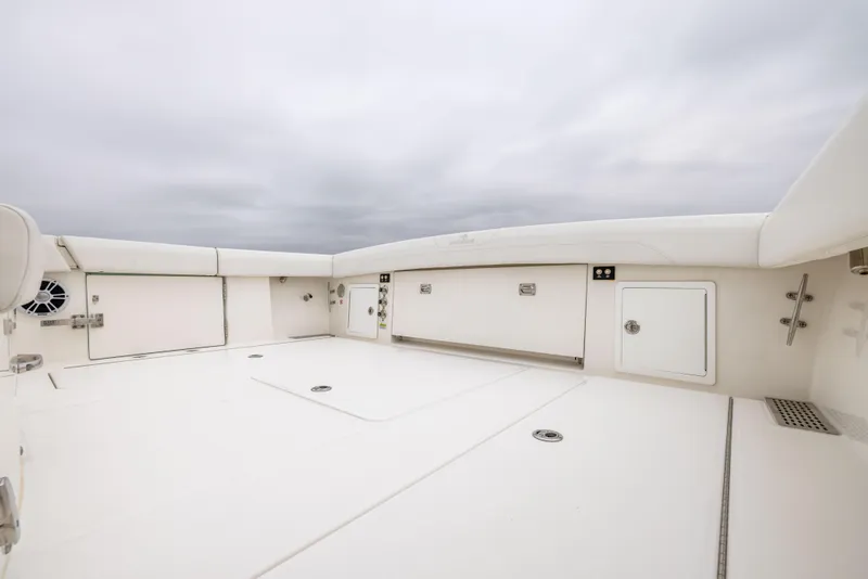 Slide: The Image of 2023 Regulator 37 boat deck with storage compartments under cloudy sky. - 23