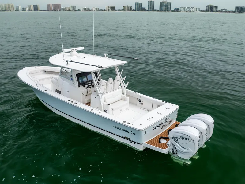 Slide: The Image of 2023 Regulator 37 boat with triple Yamaha engines on calm water. - 3