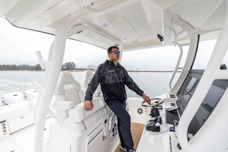 Slide: The Image of Man steering 2023 Regulator 37 boat on open water. - 47