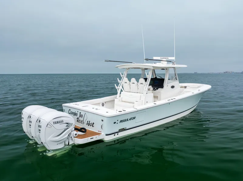 Slide: The Image of 2023 Regulator 37 boat on calm water, featuring twin Yamaha engines. - 5