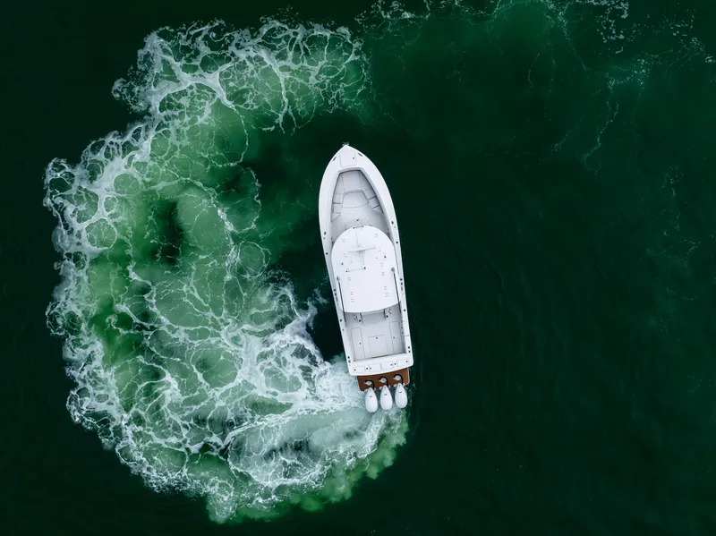 Slide: The Image of Aerial view of 2023 Regulator 37 boat making a circular wake in green water. - 8
