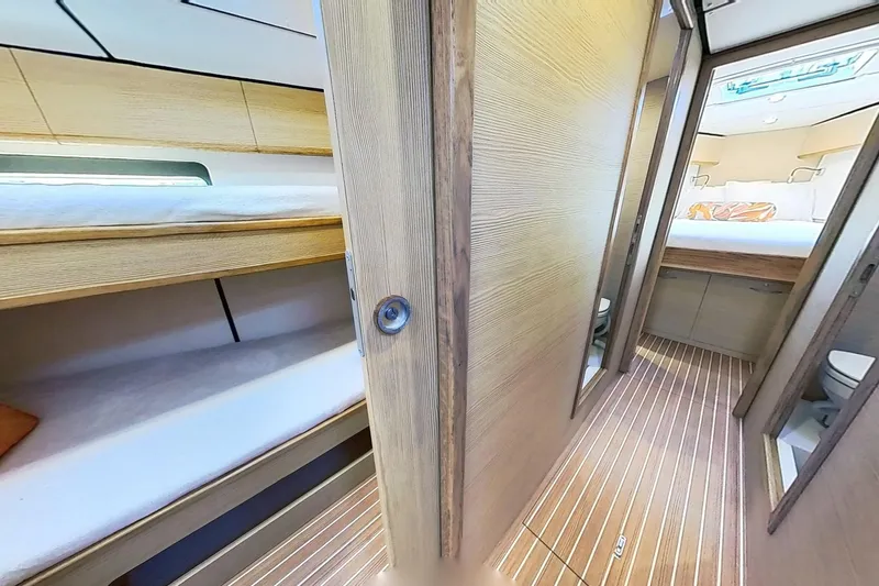 Slide: The Image of 2024 Kufner 54 yacht interior with wooden finish, featuring bunk beds and a cozy cabin. - 29