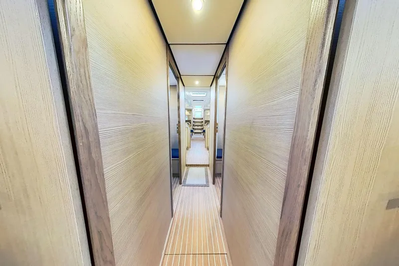 Slide: The Image of Narrow hallway inside 2024 Kufner 54 yacht, featuring wooden paneling and modern lighting. - 35