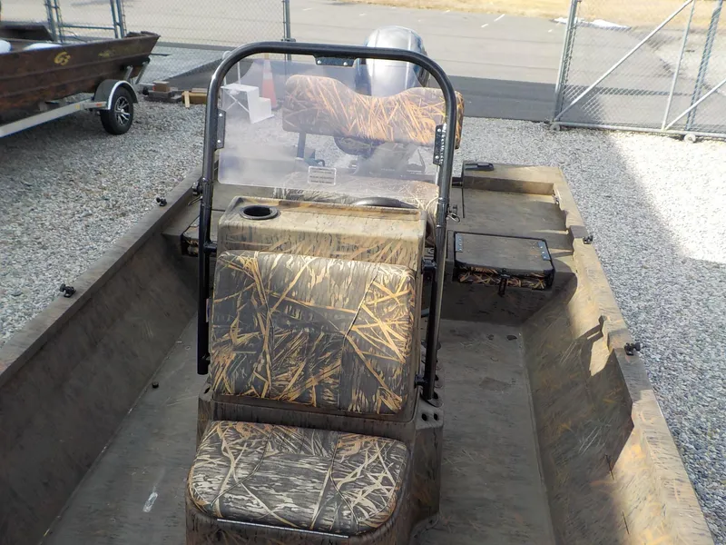 Slide: The Image of 2022 G3 Bay 22 GX boat with camouflage seating and windshield, parked on gravel. - 29