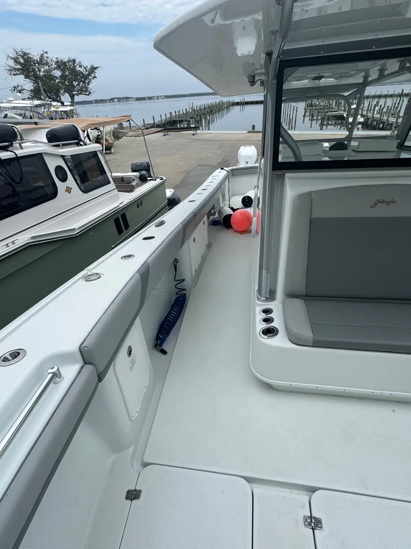 Slide: The Image of 2017 Yellowfin 39 Offshore boat docked, showcasing spacious deck and seating area. - 16