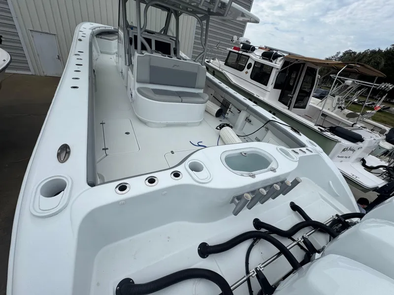 Slide: The Image of 2017 Yellowfin 39 Offshore boat with spacious deck and seating, docked near other vessels. - 3