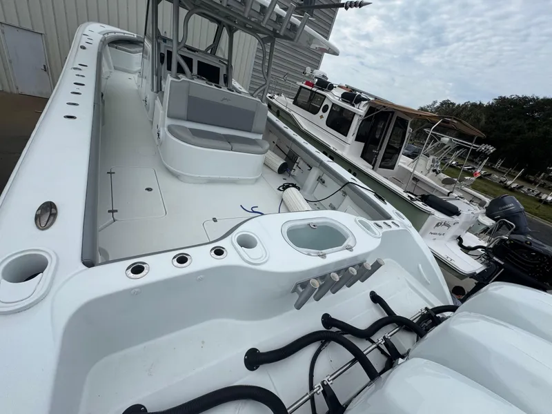 Slide: The Image of 2017 Yellowfin 39 Offshore boat with spacious deck and seating, docked near other vessels. - 4