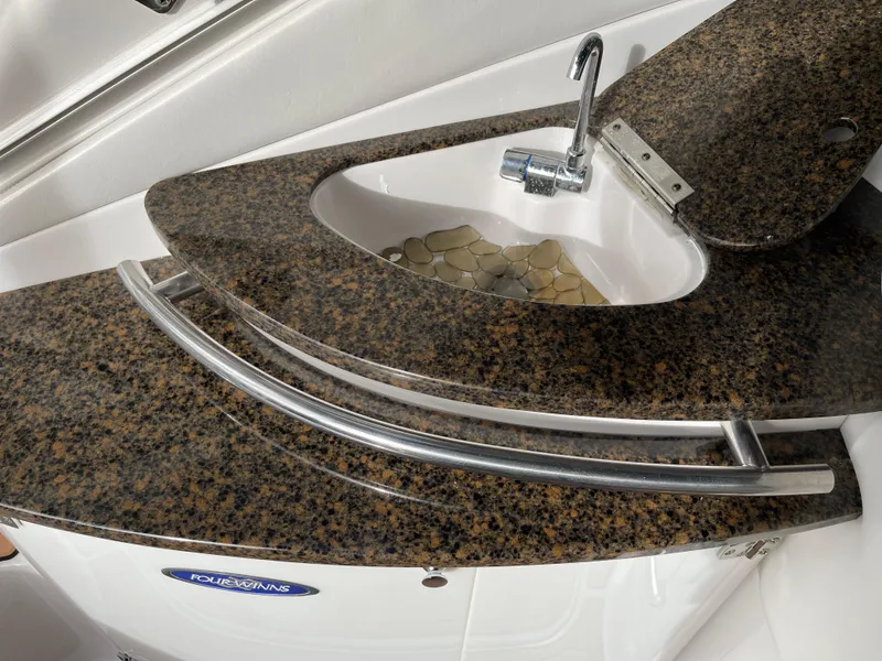 Slide: The Image of Granite countertop with sink on 2006 Four Winns 350 boat, featuring sleek metal railing. - 11