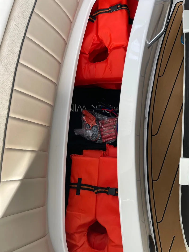 Slide: The Image of Storage compartment on a 2006 Four Winns 350 boat with orange life jackets. - 14