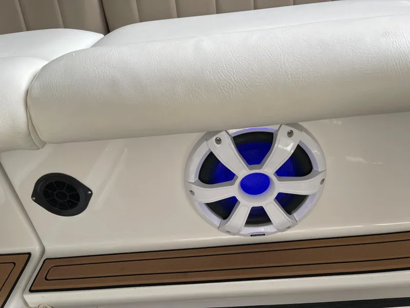 Slide: The Image of 2006 Four Winns 350 boat interior with white seating and blue-lit speaker. - 16