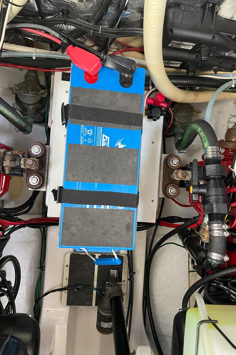 Slide: The Image of Engine compartment of a 2006 Four Winns 350 boat, featuring a blue battery. - 27