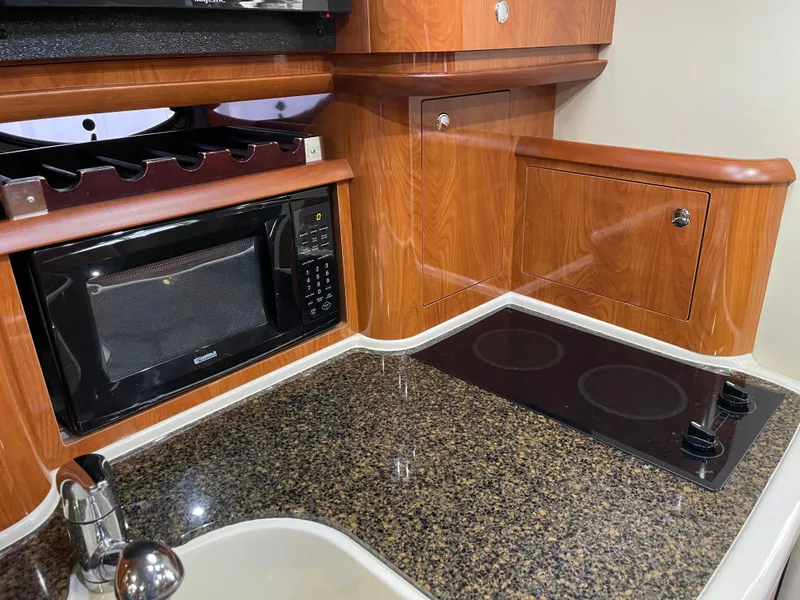 Slide: The Image of 2006 Four Winns 350 yacht kitchen with microwave, stove, and wood cabinetry. - 37