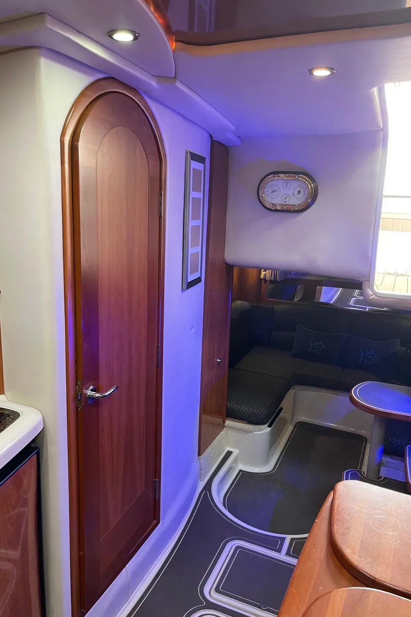 Slide: The Image of Interior of 2006 Four Winns 350 boat with wood accents and cozy seating area. - 46