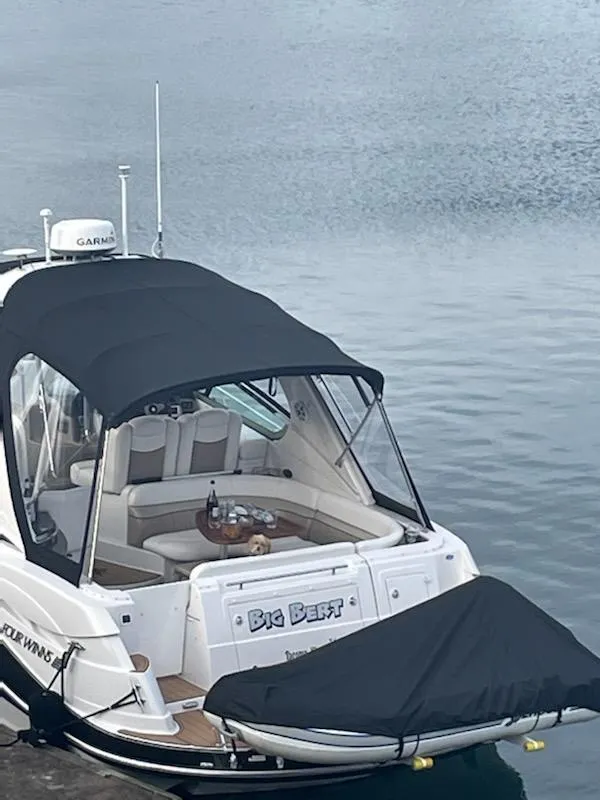 Slide: The Image of 2006 Four Winns 350 boat docked, featuring a covered seating area and sleek design. - 6